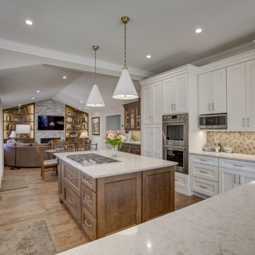 Modern kitchen design featuring an island with a cooktop, white cabinetry, and pendant lighting, showcasing BKC Kitchen and Bath's innovative remodeling style.