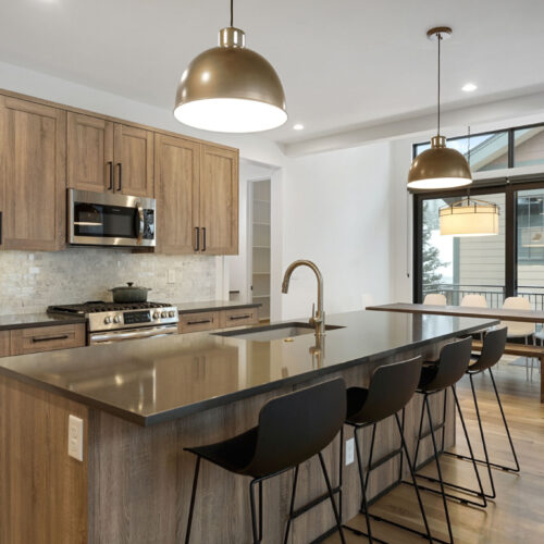Modern kitchen design featuring wooden cabinetry, stainless steel appliances, and a spacious island with seating, showcasing BKC Kitchen and Bath's innovative remodeling services.
