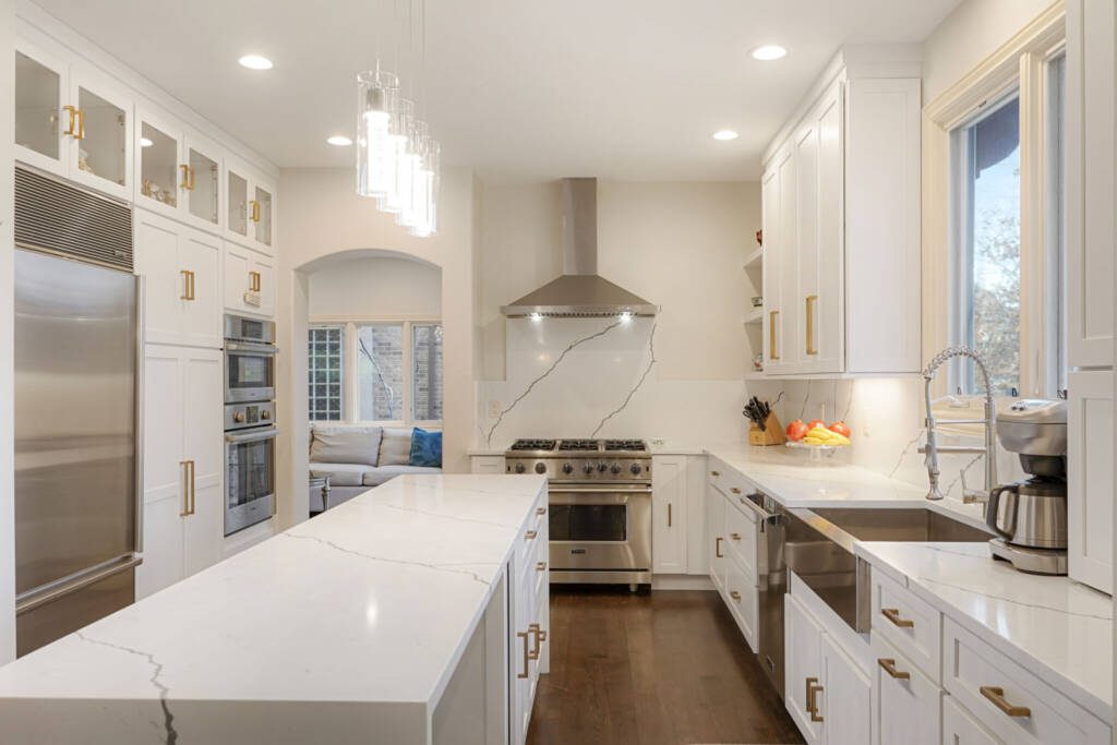 white kitchen with marble backsplash and gold hardware