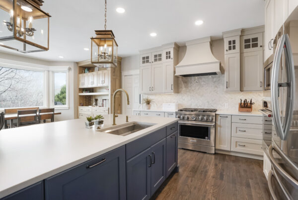 BKC Kitchen and Bath transitional kitchen with cream painted cabinets, blue painted center island, and natural hickory hutch