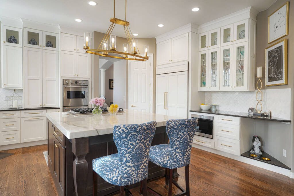 BKC Kitchen and Bath white traditional kitchen with dark wood center island and blue chair stools