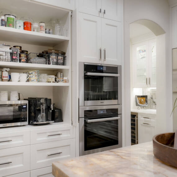 Integrated kitchen storage with white Shaker cabinets