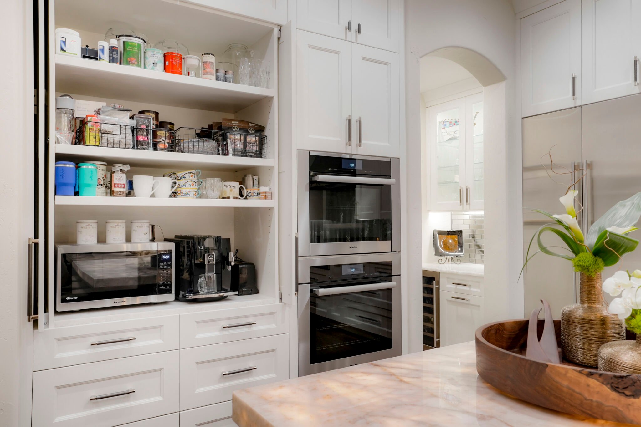 Integrated kitchen storage with white Shaker cabinets