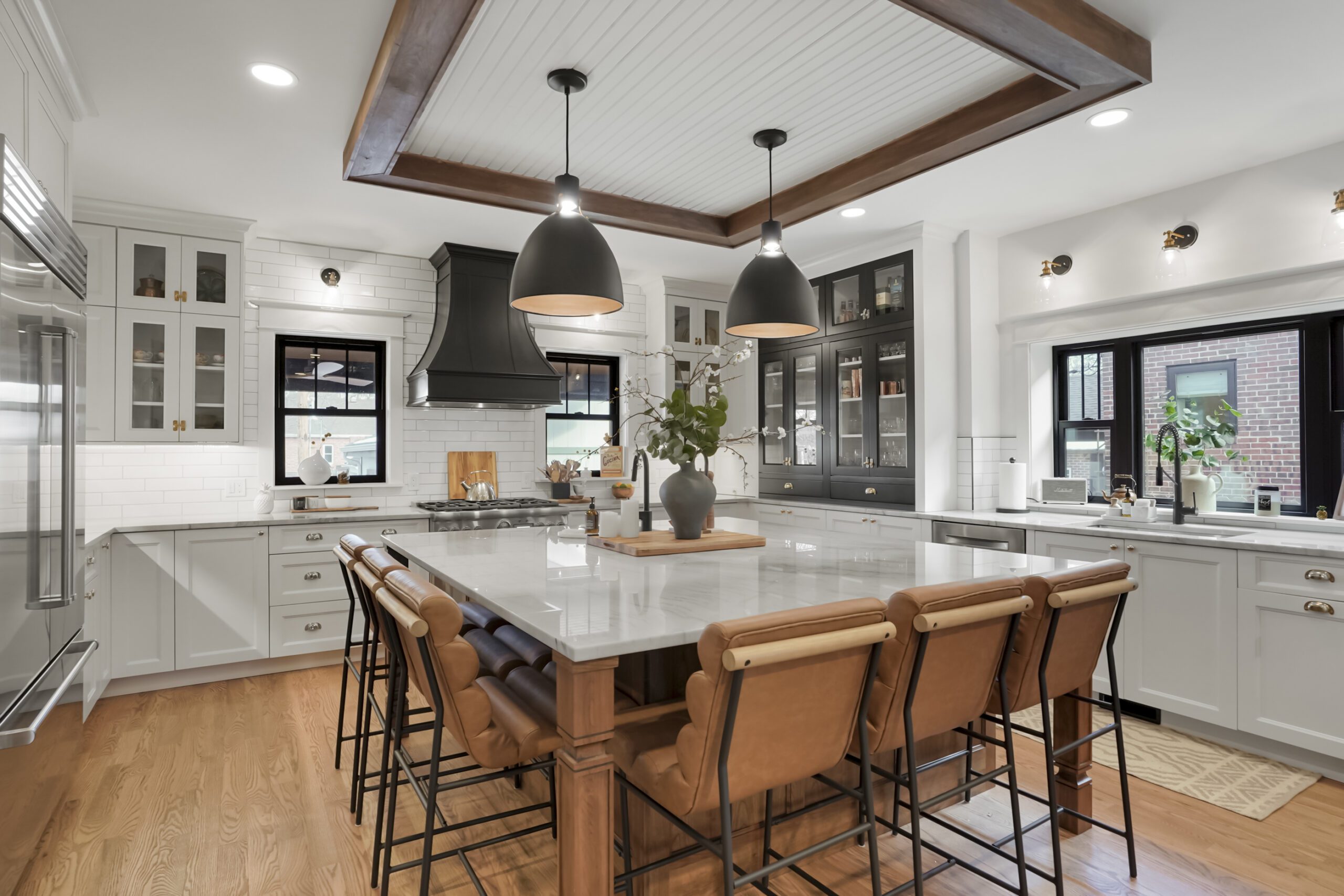 Transitional style kitchen renovation featuring walnut, white, and black cabinets with French country charm