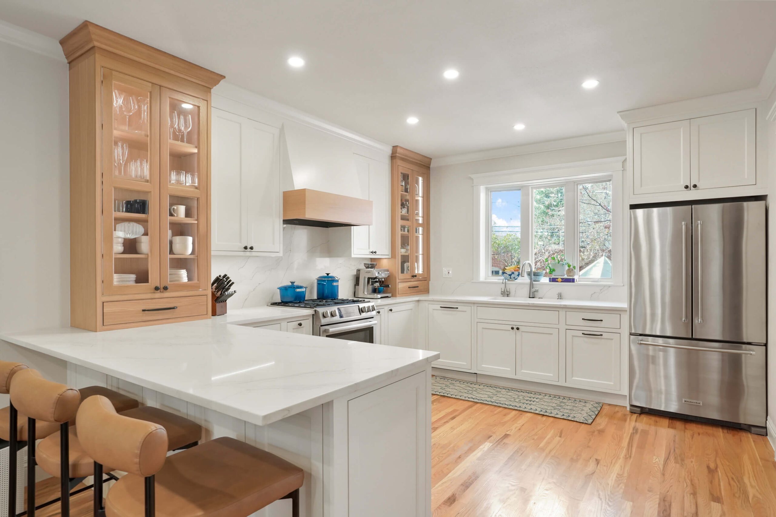 Warm white kitchen by BKC Kitchen and Bath with maple wood counter cabinets.